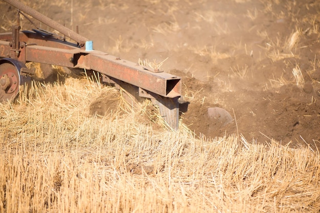 Foto landwirtschaft blauer traktor, der im herbst auf dem feld pflügt