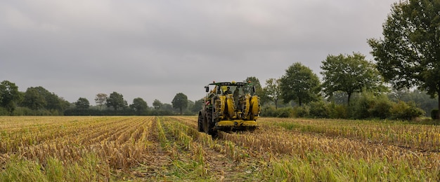 Foto landwirtschaftliche maschinen traktor und hubschrauber während der maisernte