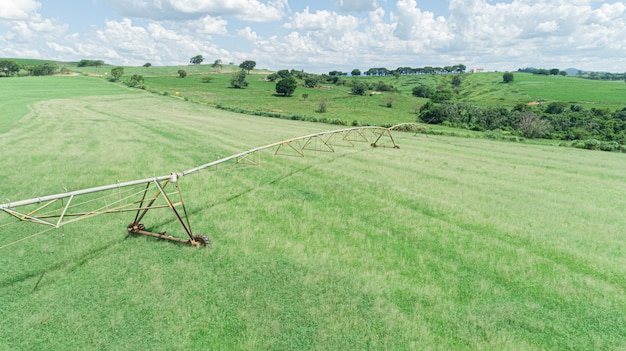 Landwirtschaftliches Bewässerungssystem am sonnigen Sommertag. Eine Luftaufnahme einer Sprinkleranlage mit zentralem Drehpunkt.