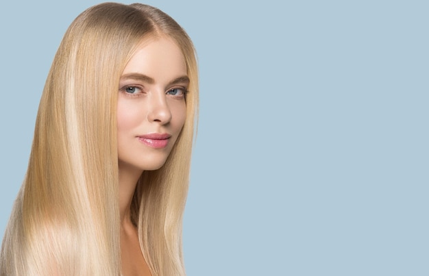 Lang glattes Haar Schönheit Frau Porträt blonde Frisur gesunde Haarhaut. Farbiger Hintergrund. Blau