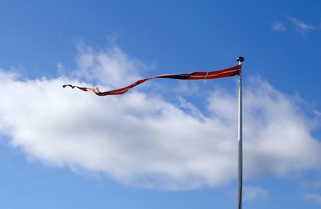 Lange Flagge von Dänemark gegen blauen Himmel