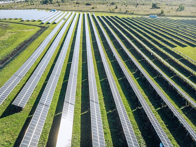 Lange Sonnenkollektoren in einem Feld hintereinander. Blick aus der Drohne. Riesige Sonnenkollektoren unter der Sonne. Solarkonzept