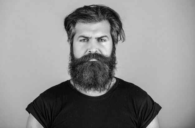 Langer Bart Perfekter Bart Nahaufnahme eines jungen bärtigen Mannes, der vor blauem Hintergrund steht