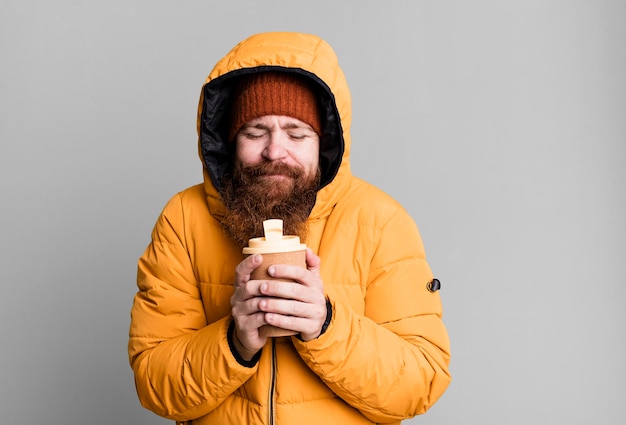 Langer Bart und rotes Haar cooler Mann mit Hut und Mantel Kälte- und Winterkonzept
