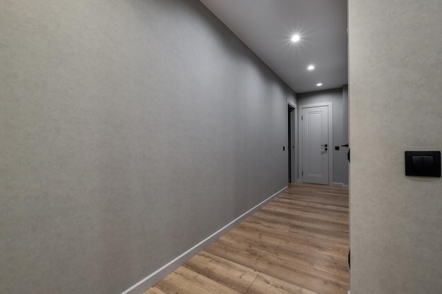 Langer leerer Korridor im Inneren der Eingangshalle moderner Apartments, Büros oder Kliniken