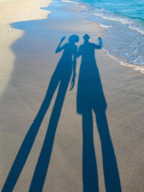 Langer Schatten von einem Paar von einem Mann und einem Mädchen auf dem Sand von Varadero Strand in Kuba Abend Sonnenuntergang