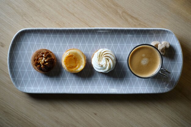 Langer Teller mit Kaffee und drei leckeren Mini-Desserts