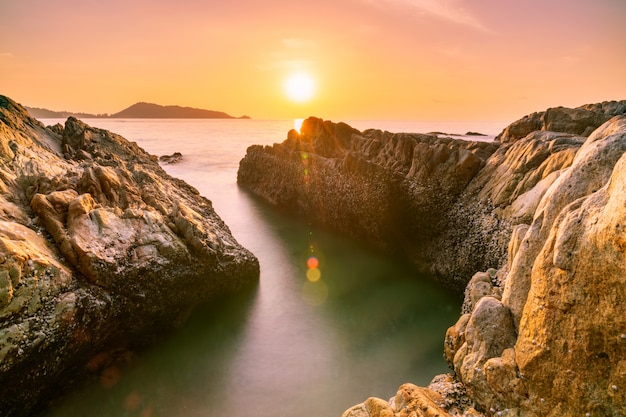 Langes Belichtungsbild des drastischen Himmelmeerblicks mit Felsen in der Sonnenunterganglandschaft