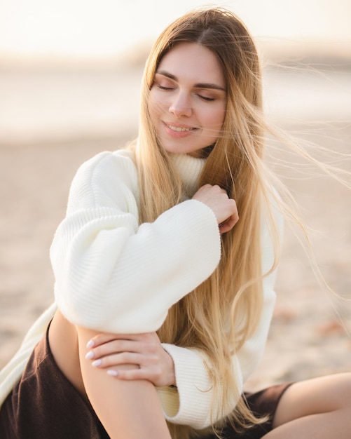 Langhaarige Blondine am Flussufer Glückliches junges Mädchen entspannt sich an einem Herbsttag