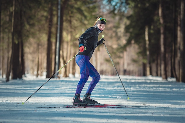 Langlauffrau, die klassisches nordisches Langlaufen auf Wanderwegen im schneebedeckten Wald macht Trainingsstrecke für Skifahrer im Park von Moskau Odintsovo