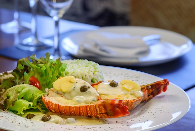 Langosta con arroz y ensalada en una mesa de madera Mesa de mariscos