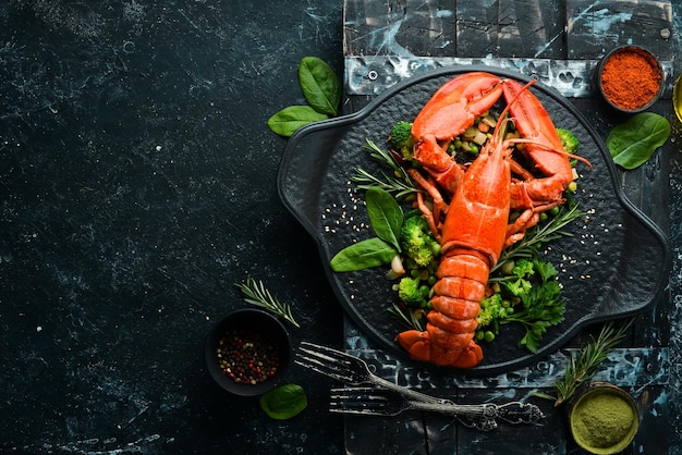 Langosta hervida con verduras en un plato de piedra negra Mariscos Vista superior Espacio libre para su texto