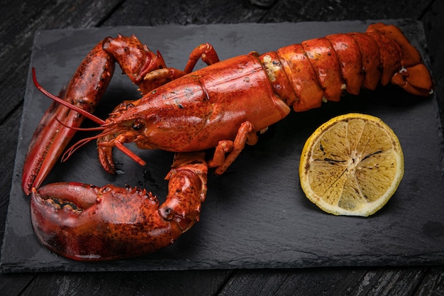 Langosta con limón sobre placa de pizarra negra