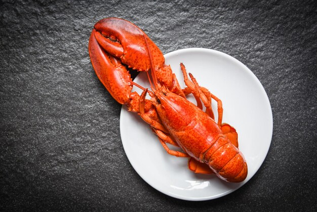 Foto langosta en plato blanco con fondo oscuro mariscos camarón camarón