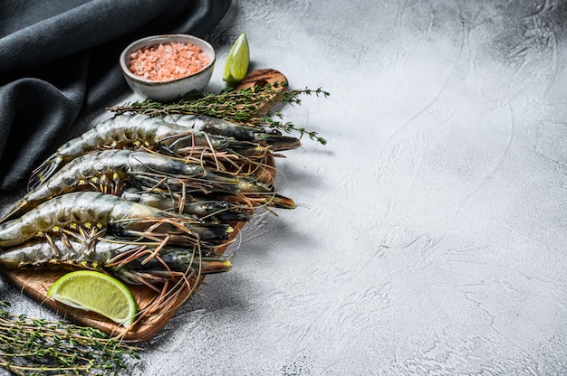 Langostinos crudos negros, camarones en una tabla de cortar