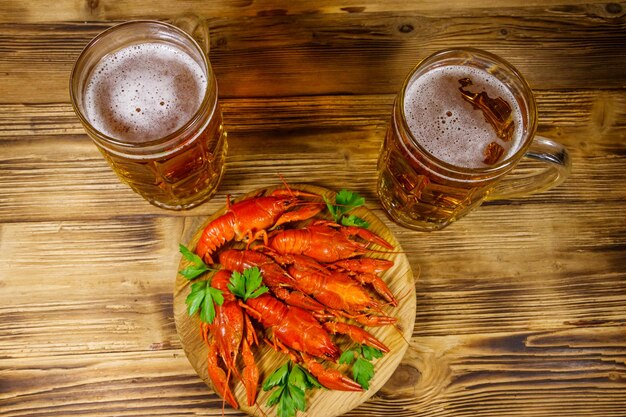 Langostinos hervidos y dos jarras de cerveza en una mesa de madera