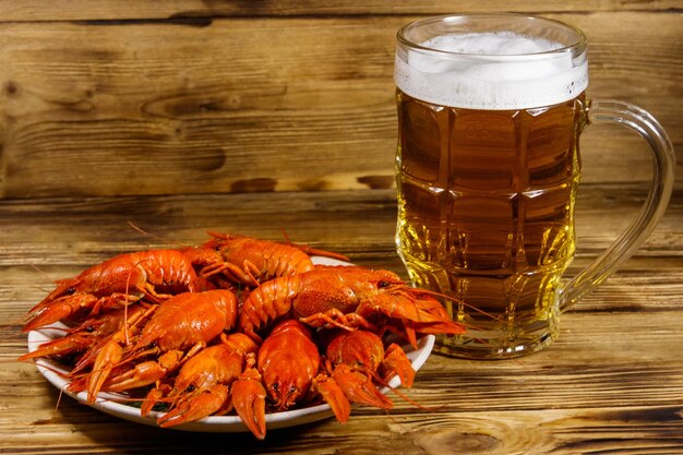 Langostinos hervidos y jarra de cerveza en una mesa de madera