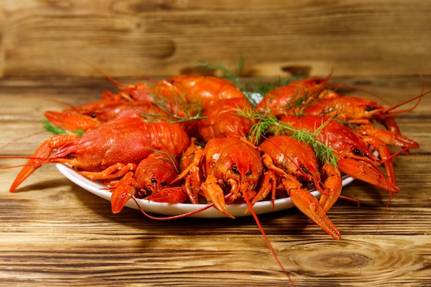 Langostinos hervidos en plato sobre mesa de madera