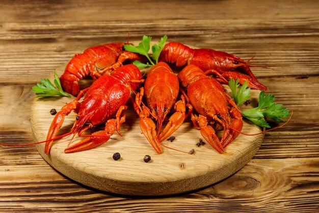 Langostinos hervidos en tabla de cortar en mesa de madera