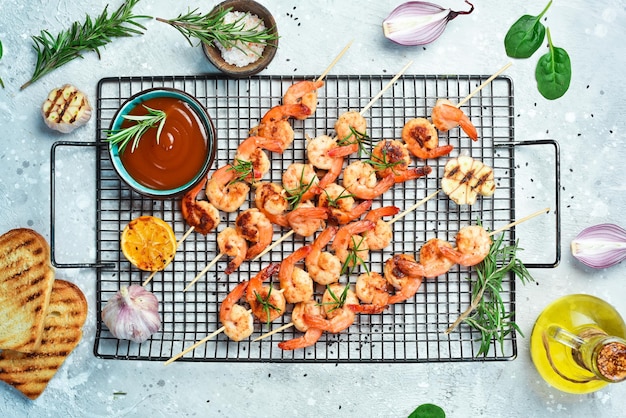 Langostinos a la parrilla en brochetas con limón y ajo Mariscos sobre un fondo de piedra