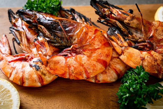 Langostinos a la plancha o gambas con limón sobre tablero de madera