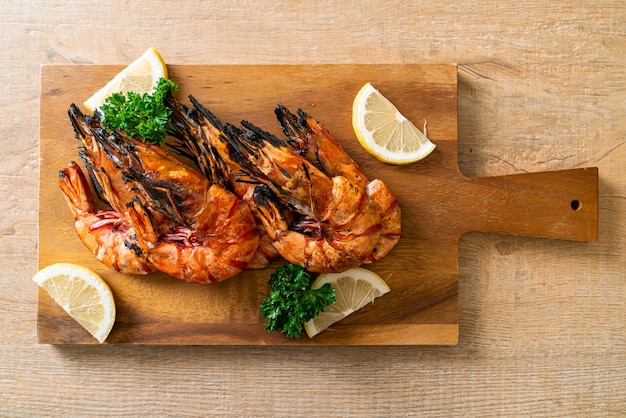 Langostinos a la plancha o gambas con limón sobre tablero de madera