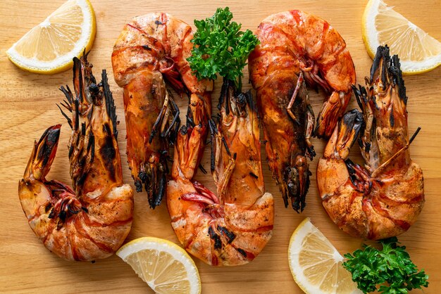 Langostinos a la plancha o gambas con limón sobre tablero de madera