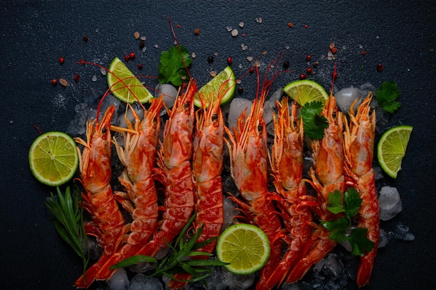 Langoustines australianos recém-congelados no gelo vista de cima de limão e verdes