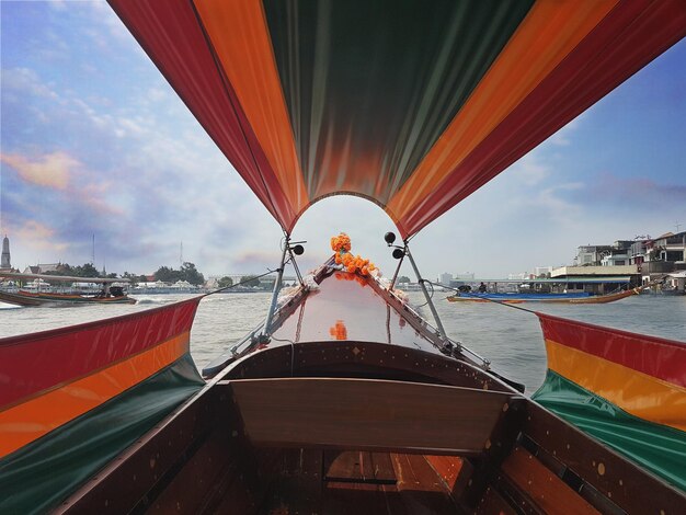 Langschwanzboot fährt im Fluss gegen den Himmel