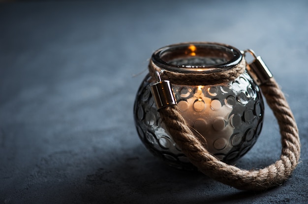 Lanterna com uma vela acesa na mesa de concreto