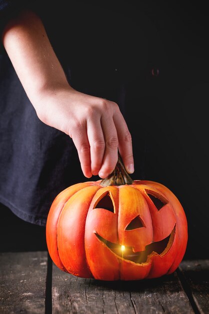 Foto lanterna de abóbora de halloween nas mãos da criança