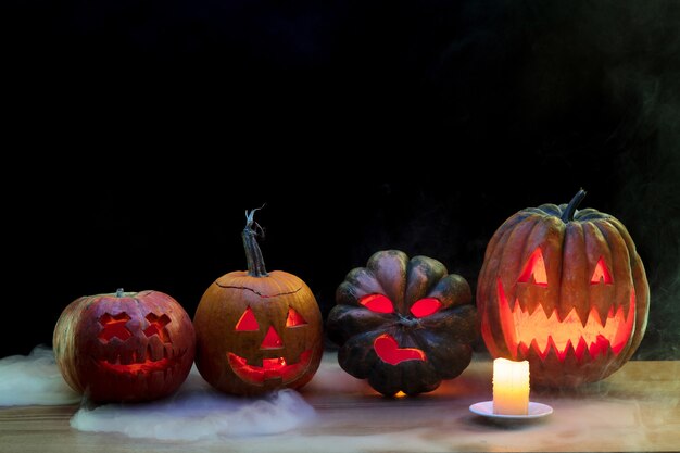 Lanterna de cabeça de abóbora de Halloween com rostos malignos assustadores e velas