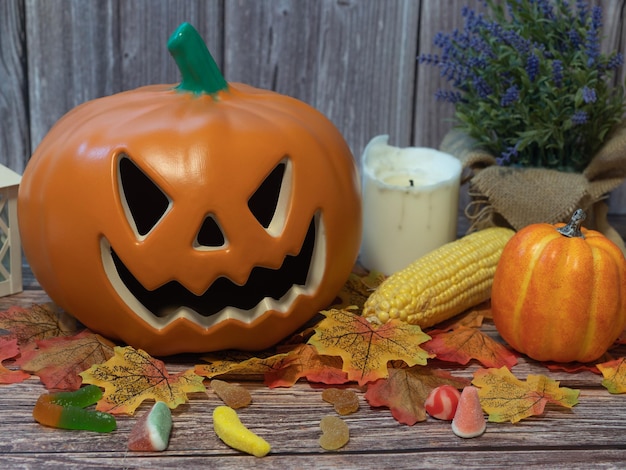 Lanterna de cabeça de abóbora de Halloween com velas e uma abóbora em fundo de madeira