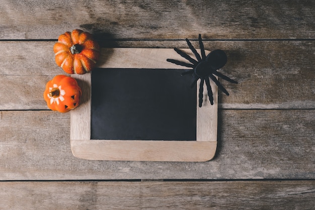 Lanterna de jack cabeça de abóbora de Halloween com placa de giz e aranha de brinquedo preto