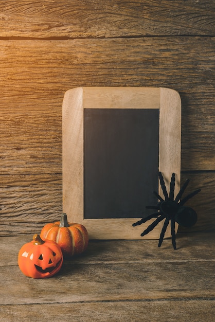 Foto lanterna de jack cabeça de abóbora de halloween com placa de giz e aranha preta