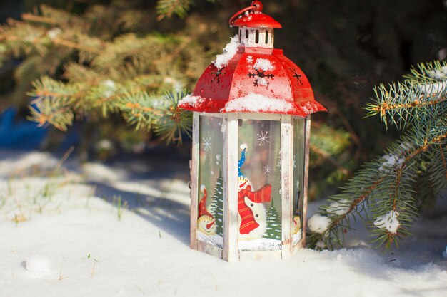 Lanterna de Natal decorativa perto de ramo de abeto na neve, dia de inverno