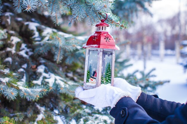 Lanterna de Natal decorativa vermelha linda em luvas quentes