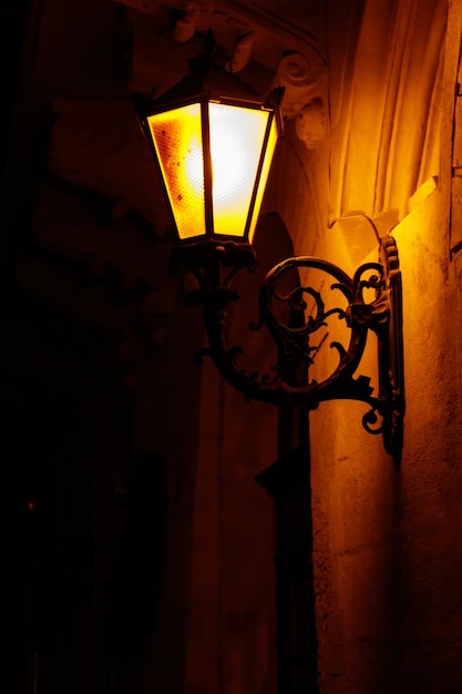 Lanterna de rua vintage iluminada na parede de uma casa à noite