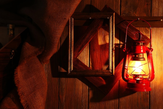 Lanterna pendurada no gancho na parede de madeira