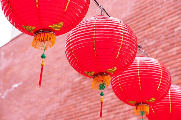 Lanterna vermelha redonda bonita pendurada na velha rua tradicional, o conceito do festival do ano novo lunar chinês, close-up. A palavra subjacente significa bênção.