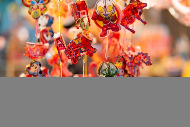 Lanternas coloridas decoradas penduradas em um suporte nas ruas da cidade de Ho Chi Minh, Vietnã, durante o Festival do Meio Outono Língua chinesa em fotos significam dinheiro e felicidade Foco seletivo