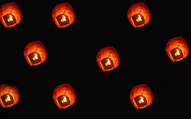 Lanternas de papel no céu noturno. dentro da lanterna, o fogo queima em vermelho. uma bela tradição.