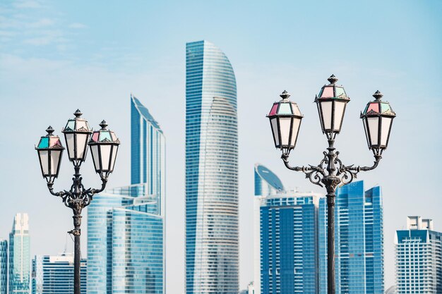 Lanternas decorativas urbanas erguendo-se nos arranha-céus de Abu Dhabi enquanto se erguem para encontrar o céu azul sem fim em uma impressionante exibição de arquitetura moderna