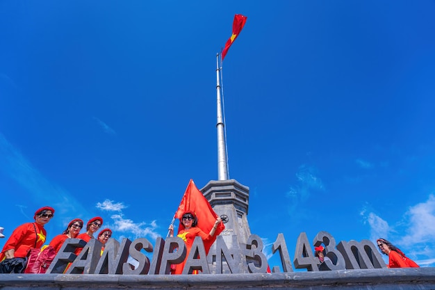 Lao Cai Vietnam MAR 12 2023 Personas con banderas en la cima del monte Fansipan cumbre fansipan pico de montaña más alto de indochina sapa lao cai provincia norte de vietnam