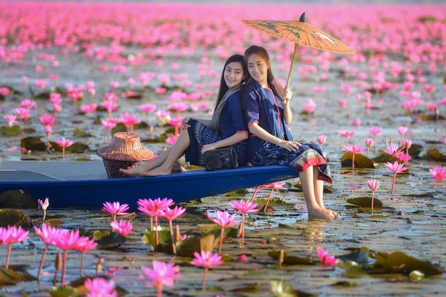 Laos, mujer, en, flor, lago de loto, mujer, llevando, pueblo tailandés tradicional, mar de loto rojo, UdonThani, Tailandia