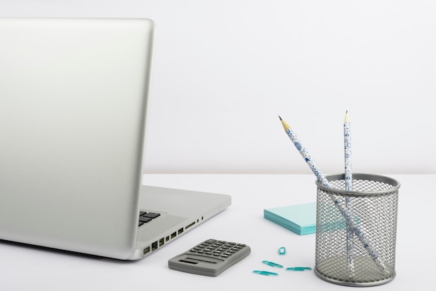 Lap top case com lápis calculadora clips e notas adesivas colocadas em canetas de computador de mesa