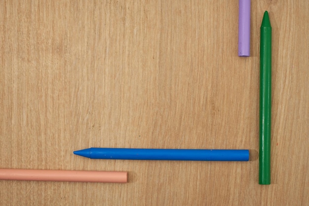 Lápices de cera multicolores para niños para dibujar sobre una mesa de madera.