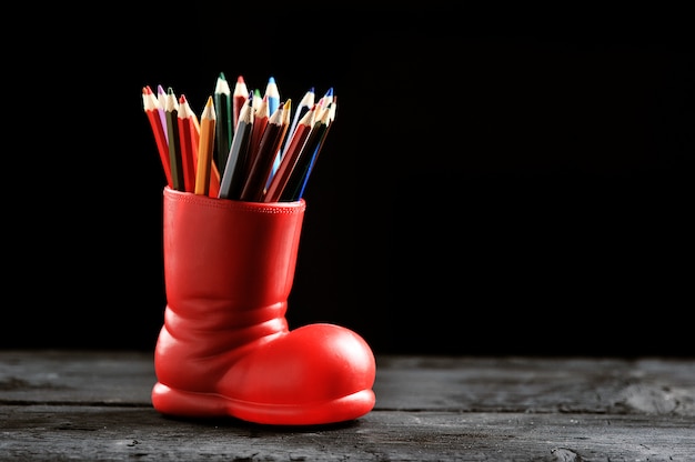 Lápices de colores en una bota roja en