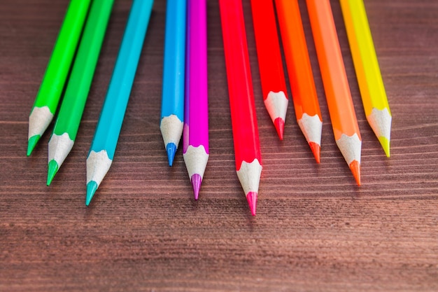 Lápices de colores brillantes en la mesa de madera