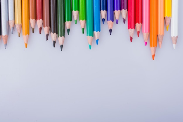 Lápices de colores colocados sobre un fondo blanco.